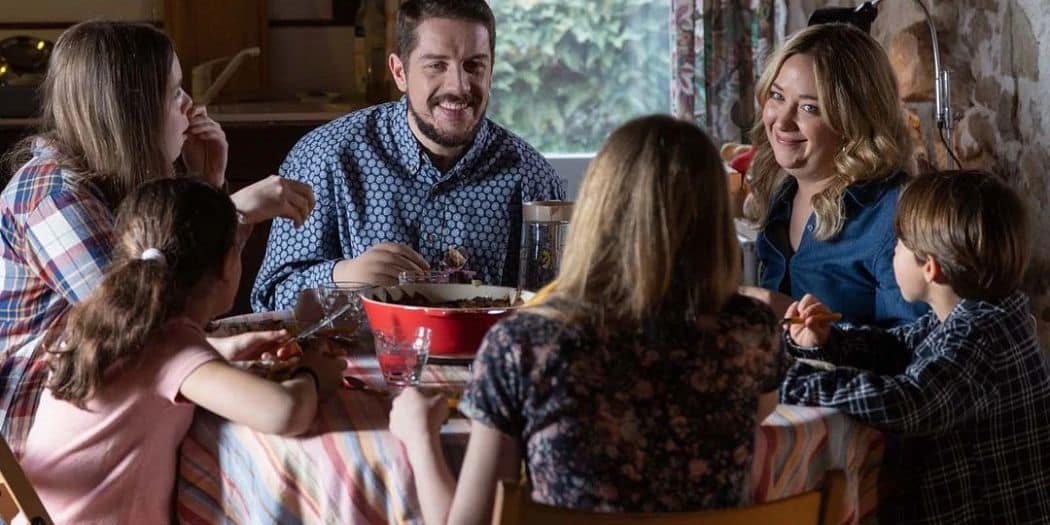 Scène de repas du film Pour le meilleur : Pierre Rabine et Lilly-Fleur Pointeaux souriants autour d'une table entourés d'enfants.