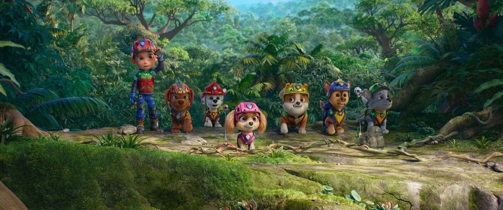 Ryder et les sept chiots de la Pat'Patrouille alignés sur un rocher dans la jungle, dans Mission Dino