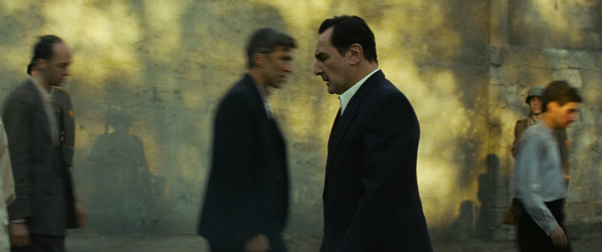 Gilles Lellouche dans le rôle de Jean Moulin, marchant parmi des passants dans Moulin (2026).