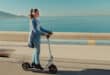 Marilou Aussilloux, casque audio sur les oreilles, à trottinette devant la mer dans Une femme aujourd’hui.